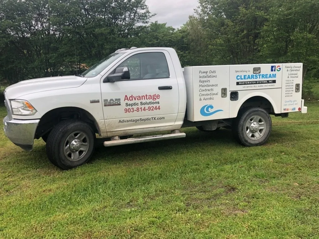 A white Advantage Septic Solutions service pickup with lettered utility bed